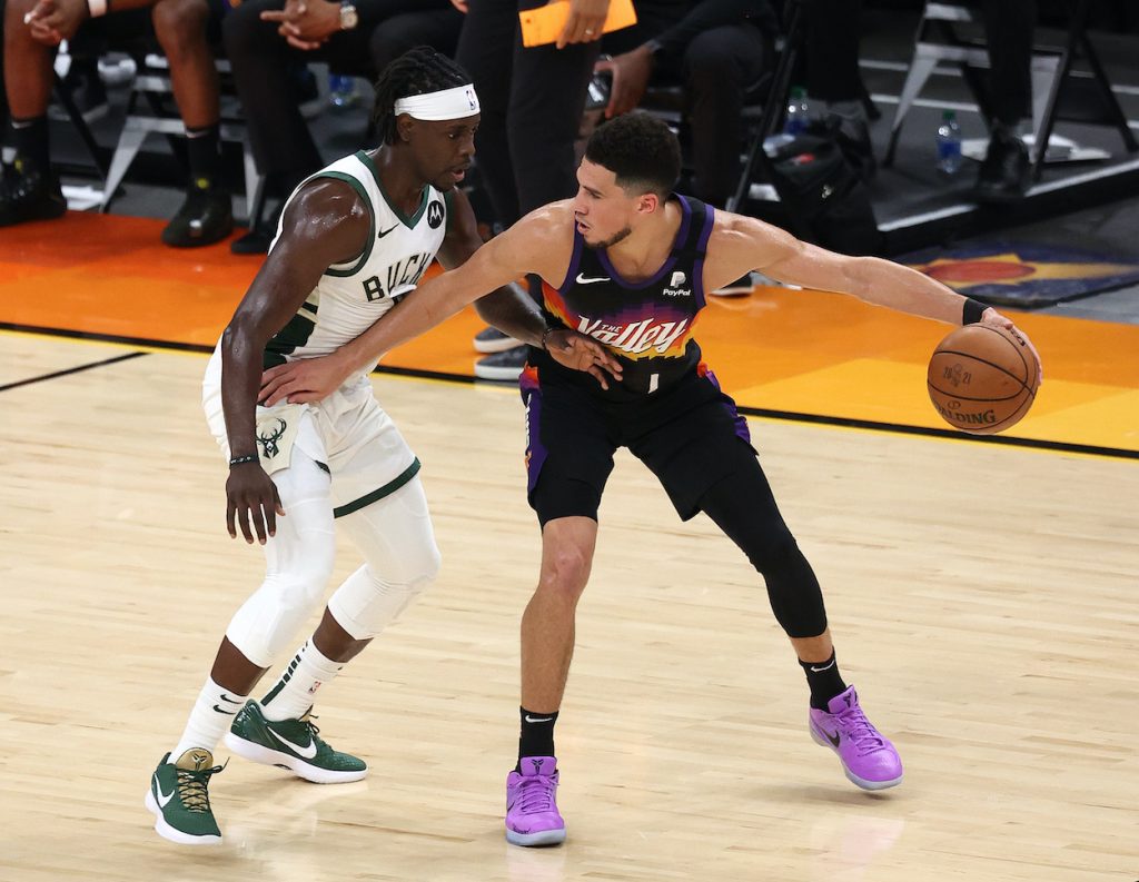 Jrue Holiday defends Devin Booker.