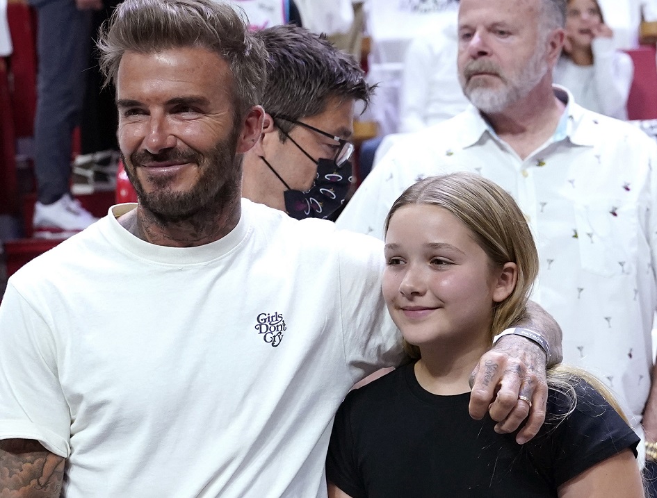 David Beckham stands with his daughter Harper Seven Beckham during the first half of Game 2 of an NBA basketball first-round playoff series between the Miami Heat and Atlanta Hawks, Tuesday, April 19, 2022, in Miami. (AP Photo/Lynne Sladky)