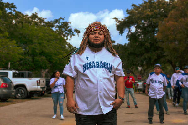 Luis Lazo poses wearing a headdress and a Nicaragua jersey.