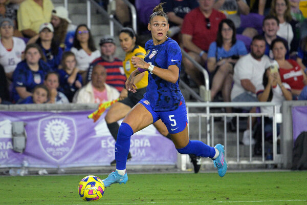 The U.S. player Trinity Rodman runs while controlling a ball with her right foot and looks to her left.