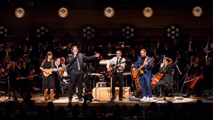 Several musicians are active on stage, with four members of the Cowboys Fringeants in the foreground. 