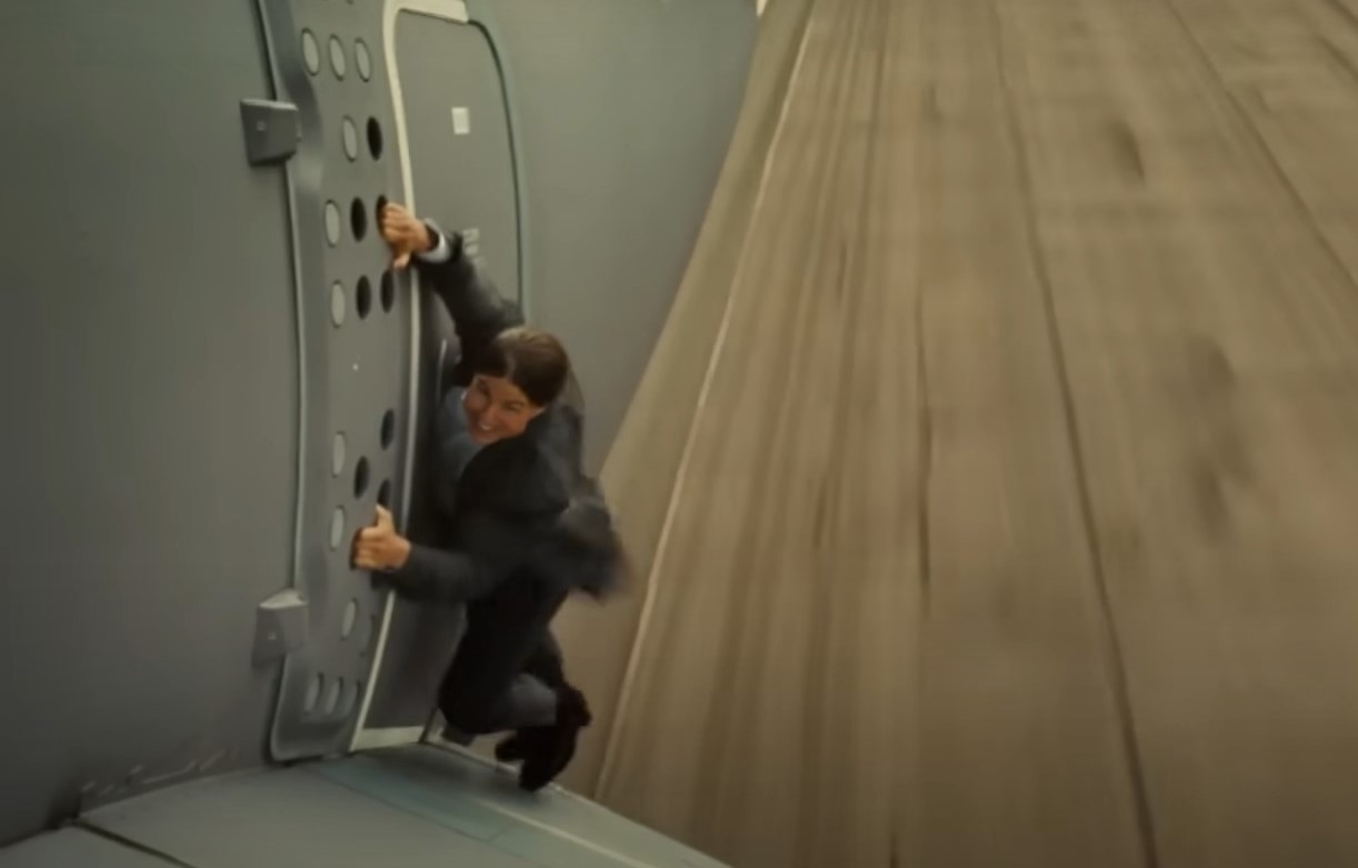 Tom Cruise hanging onto the side of a plane for a Mission: Impossible stunt