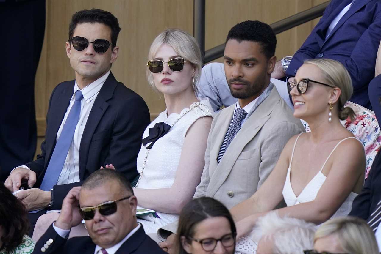 Actors Rami Malik, Lucy Boynton, Rene-Jean Page and Emily Brown, from left, sit in the Royal Box on Centre Court to watch Serbia's Novak Djokovic and Britain's Cameron Norrie in a men's singles semifinal on day twelve of the Wimbledon tennis championships in London, Friday, July 8, 2022 