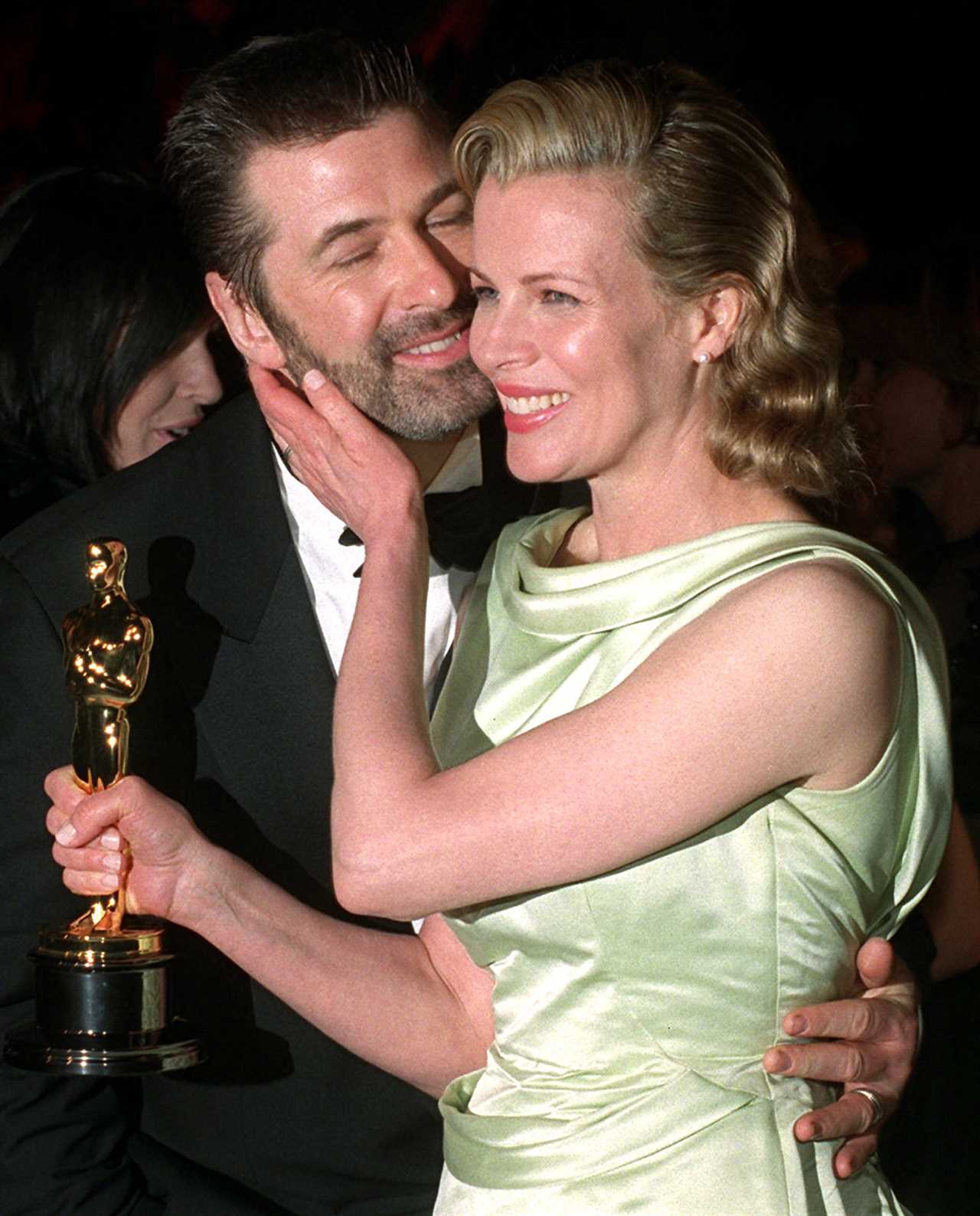 Holding her Oscar, Kim Basinger embraces her husband Alec Baldwin at a post Academy Awards party