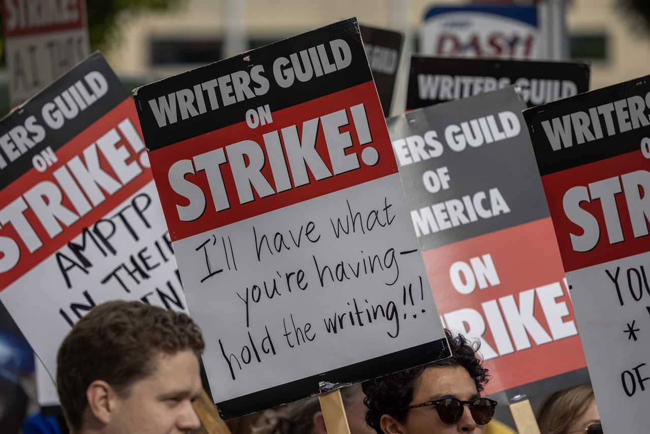LOS ANGELES, CA - MAY 04: People picket outside of Paramount Pictures studios during the Hollywood writers strike on May 4, 2023 in Los Angeles, California. Scripted TV series, late-night talk shows, film and streaming productions are being interrupted by the Writers Guild of America (WGA) strike. In 2007 and 2008, a WGA strike shut down Hollywood productions for 100 days, costing the local economy between $2 billion and $3 billion. (Photo by David McNew/Getty Images)